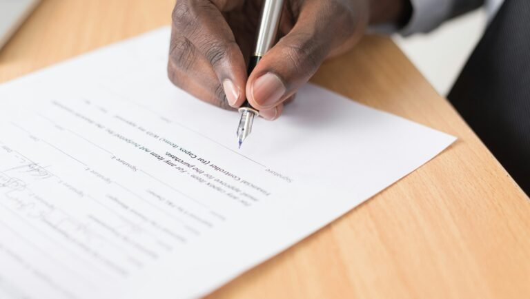 henkilo allekirjoittamassa tyosopimusta toimistossa