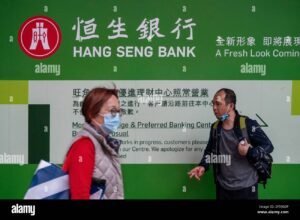 hymyileva henkilo kavelee pankin edessa