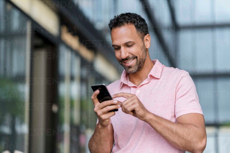 hymyileva henkilo kayttaa alypuhelinta