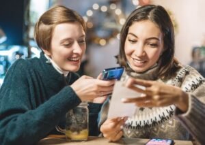 hymyilevat ihmiset jakamassa laskun yhdessa