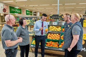 iloinen asiakas kaupassa skannaa bonuskorttiaan