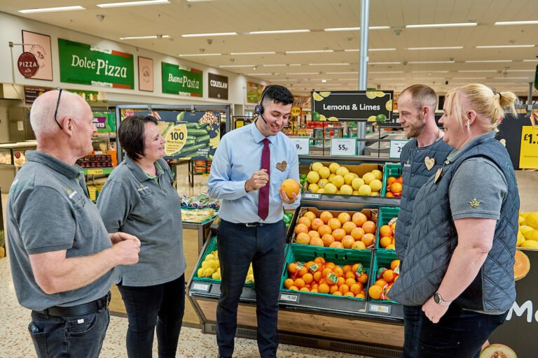 iloinen asiakas kaupassa skannaa bonuskorttiaan