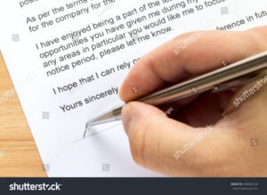 kasi allekirjoittamassa kirjetta poydalla