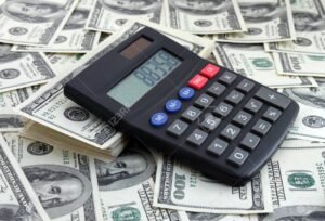 laskin ja avaimet rahapinojen paalla