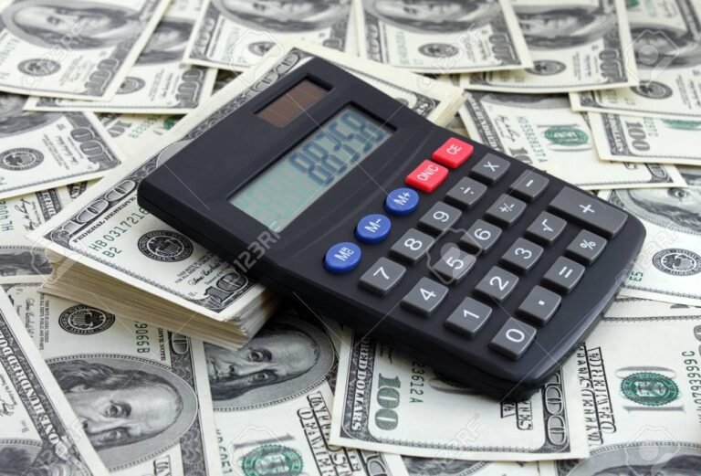 laskin ja avaimet rahapinojen paalla