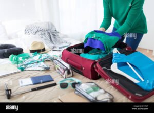 matkustaja pakkaamassa matkalaukkua kotona