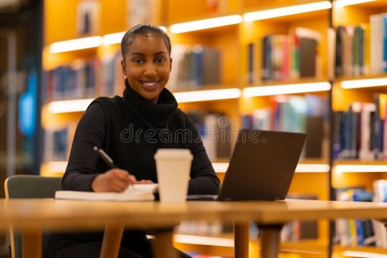 nuori opiskelija kirjasto ymparistossa opiskelemassa